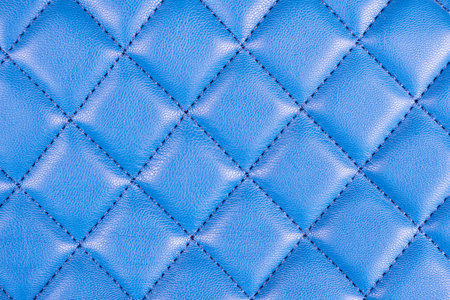 Modern luxury car blue leather interior. Part of perforated leather car seat details. Blue perforated leather texture background. Texture, artificial leather with diagonal stitching. Leather seatsの写真素材