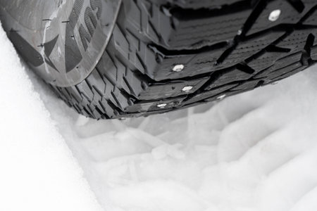 Car tire in the snow close up. Car tracks on the snow. Traces of the car in the snow. Winter tires....