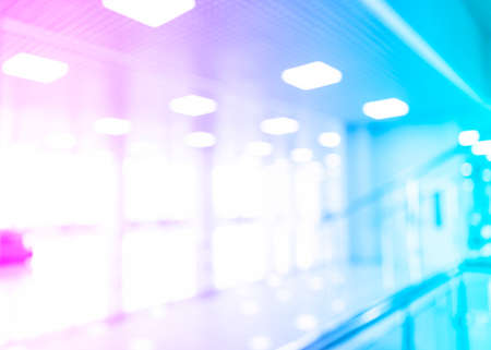 Blurred defocused bokeh background of exhibition hall or convention centre hallway. Blue and pink tones modern interior architecture. Abstract blur modern business office backgroundの写真素材