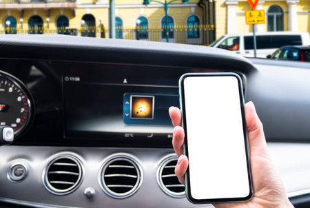 Female hand using smartphone in car. Smartphone in a car use for Navigate or GPS. Mobile phone with isolated white screen. Blank empty screen. Copy space. Empty space for text.の写真素材