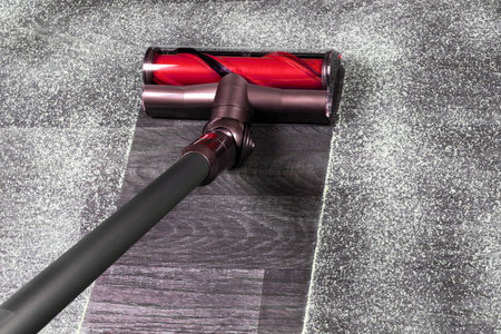 Vacuum cleaner on the floor. House cleaning concept. Before and after cleaning. Dirty and cleaned area. Housekeeping. Modern vacuum cleaner while vacuuming. Cleaning serviceの写真素材