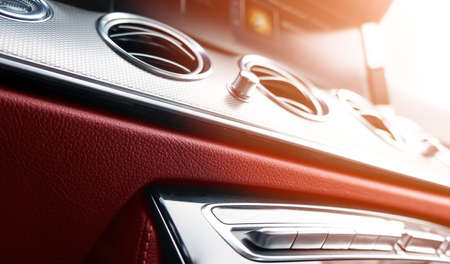 Red luxury modern car Interior. Shift lever and dashboard. Detail of modern car interior. Automatic gear stick. Part of leather seats with stitching in expensive carの写真素材