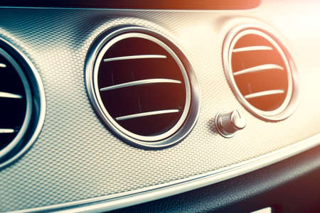 AC ventilation deck in luxury modern car Interior. Modern car black leather interior. Natural wood...