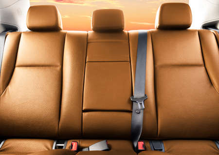 Back passenger brown leather seats in modern luxury car. Orange perforated leather with stitching....
