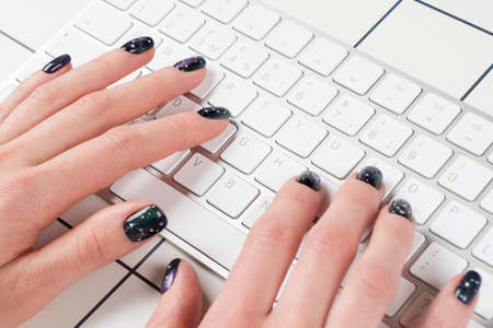 Female hand using computer keyboard. Hand typing on desktop office computer keyboard. Woman using...