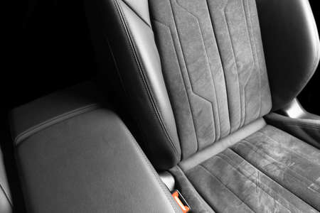 Modern luxury car black leather with alcantara interior. Part of black leather car seat details with white stitching. Interior of prestige car. Perforated leather seats isolated. Perforated leather.の写真素材
