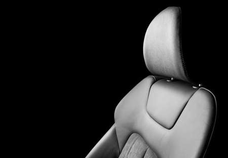 Modern luxury car black leather with alcantara interior. Part of black leather car seat details with white stitching. Interior of prestige car. Perforated leather seats isolated. Perforated leather.の写真素材