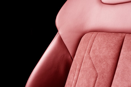 Modern luxury car red leather with alcantara interior. Part of red leather car seat details with white stitching. Interior of prestige car. Perforated leather seats isolated. Perforated leather.の写真素材