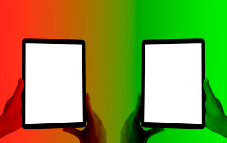 Beautiful Woman hands holding tablet computer with isolated white screen. Business workplace with copy space. Empty space for text. Isolated screen for mock up. Red and green tonesの写真素材