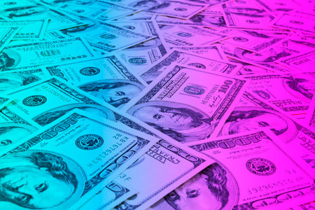 Stack of one hundred dollar bills. Stack of cash money in hundred dollar banknotes. Heap of hundred dollar bills background in blue and pink tonesの写真素材