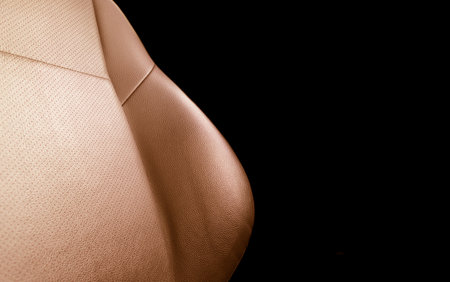 Modern luxury car brown leather interior. Part of red leather car seat details with stitching. Interior of prestige car. Comfortable perforated leather seats. Orange perforated leather.の写真素材