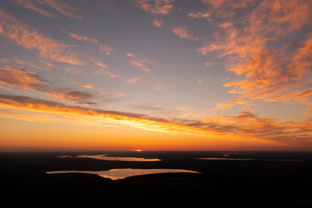 Aerial view of a sunset sky background. Aerial Dramatic gold sunset sky with evening sky clouds over the lake. Stunning sky clouds in the sunset. Sky landscape. Aerial photography.の写真素材