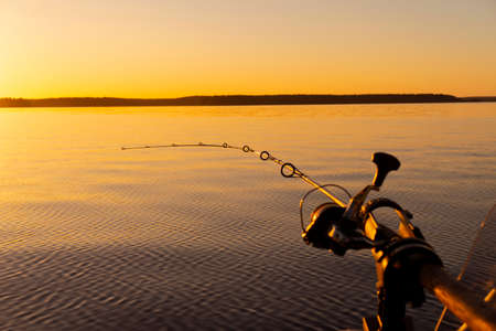 Fishing rod spinning with the line close-up. Fishing rod in rod holder in fishing boat due the...