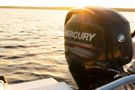 Sankt-Petersburg, Russia, August 27, 2021: Modern new fishing sport boat with a brand new Mercury FourStroke outboard engine speeding on the lake at the sunsetのeditorial素材
