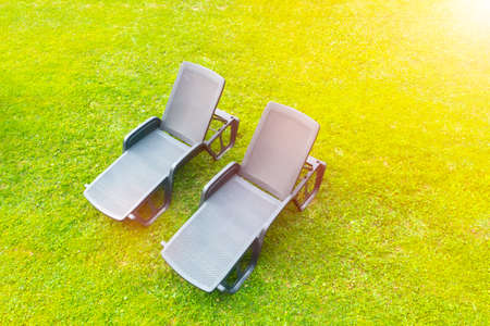Aerial view sun loungers on a green meadow with short cut lawn grass. Sunbeds on grass at the beachの写真素材