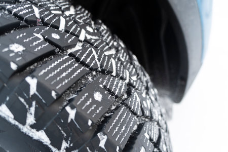 Car tire in the snow close up. Car tracks on the snow. Traces of the car in the snow. Winter tires....
