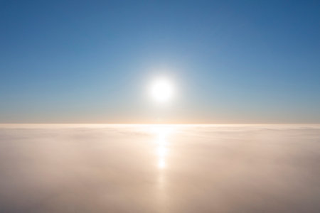 Aerial view white clouds in blue sky. View from drone. Aerial top view cloudscape. Texture of clouds. View from above. Sunrise or sunset over clouds. Airplane viewの写真素材