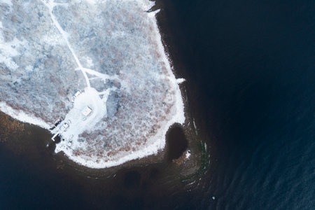 Winter landscape. Aerial view winter forest and lake. Coastline. Aerial top frozen forest. Texture of clouds. View from above. Top vew water surfaceの写真素材