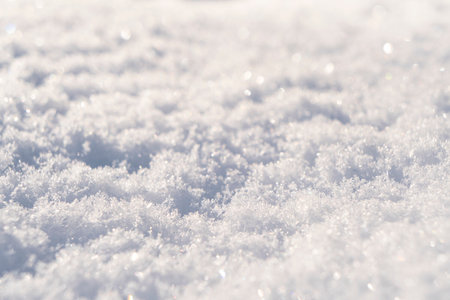 Macro shot background of fresh white snow at the sunset. Snowflakes texture. Snow texture winter background. Shiny snow with bokeh sun rays.の写真素材