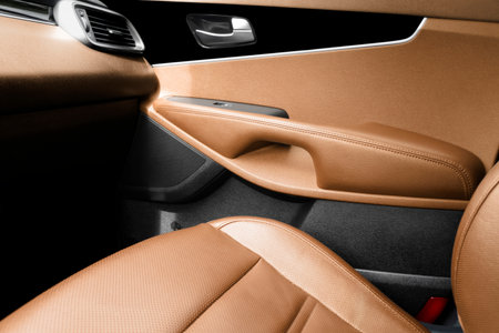 Modern luxury car brown leather interior. Part of brown perforated leather car seat details with white stitching. Interior of prestige car. Comfortable perforated leather seats. Perforated leather.の写真素材