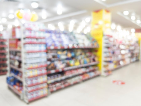 Abstract blurred background of modern luxury department store hall or shopping center mall. Blurred lights background. Blurred defocused bokeh lights with modern white interior architectureの写真素材