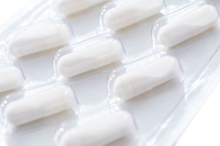 Macro shot pile of tablets pill in silver blister packaging isolated on white background. Aluminium foil blister pack. Pharmacy products. Medicine pills and drugs close up. Pills backgroundの写真素材