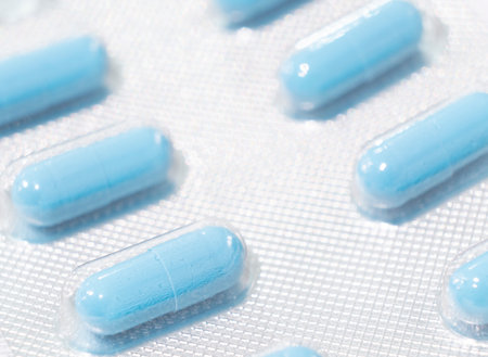 Macro shot pile of tablets pill in silver blister packaging isolated on white background. Aluminium...