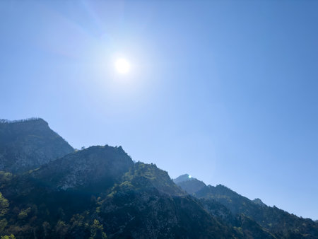 Scenic aerial mountain view to green forest valley in sunlight among mountain ranges and hills on horizon. Green landscape with sunlight mountains.の写真素材
