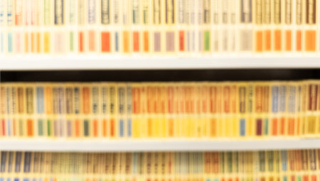 Abstract blurred modern white bookshelves with books. Blur manuals and textbooks on bookshelves in library or in book store. Concept for education. Library interior bokeh background.の写真素材