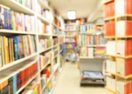 Abstract blurred modern white bookshelves with books. Blur manuals and textbooks on bookshelves in...