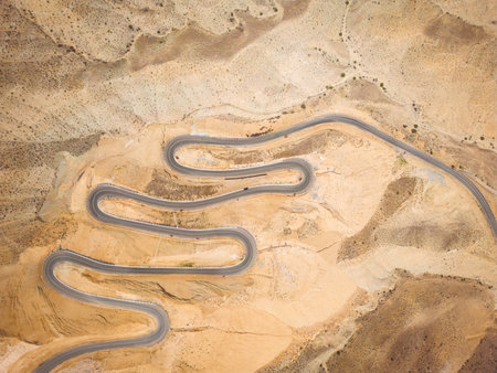 Top aerial view of snake curved road. Winding mountains road. View from above. Driveway serpentine with carsの写真素材