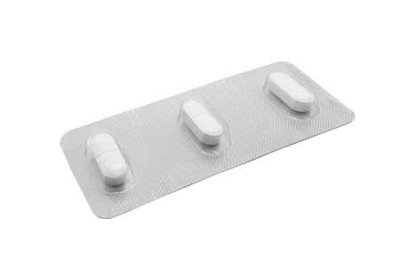 Macro shot pile of tablets pill in silver blister packaging isolated on white background. Aluminium foil blister pack. Pharmacy products. Medicine pills and drugs close up. Pills backgroundの写真素材