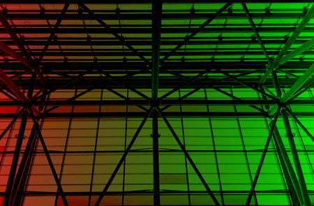 Lights and ventilation system in long line on ceiling of the  industrial building. Exhibition Hall in green and red tones. Ceiling factory constructionの写真素材