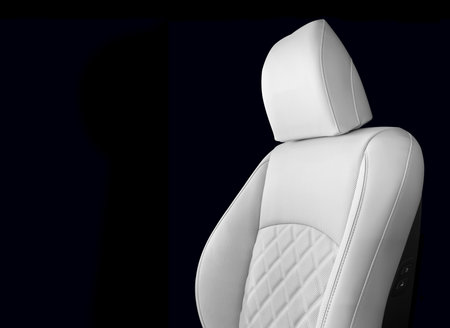Modern luxury car white leather interior. Part of white leather car seat details with white stitching. Interior of prestige car. Perforated leather seats isolated. Perforated leather.の写真素材