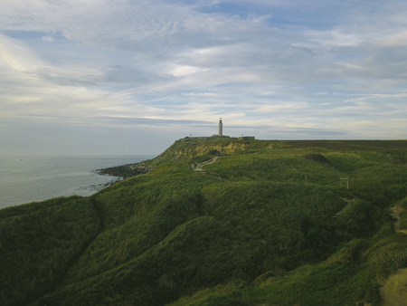 green plain with a view of the lighthouseの写真素材