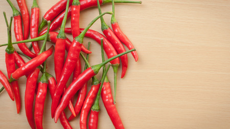 Red hot chili peppers on the wooden desk with copy space