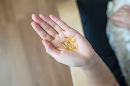 Fish Oil Capsules in Female Handの写真素材