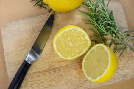 sliced lemons on a cutting board with knifeの写真素材