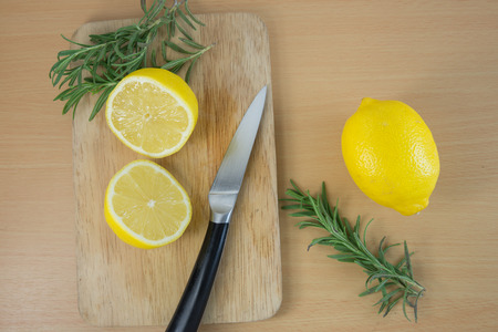 sliced lemons on a cutting board with knifeの写真素材
