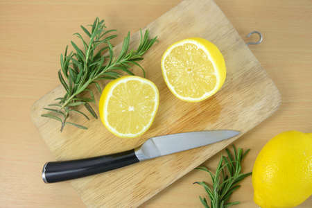 sliced lemons on a cutting board with knifeの写真素材