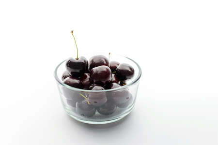 Cherries in glass bowl on white backgroundの写真素材