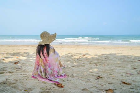 Young female relax on tropical beach looking to seaの写真素材