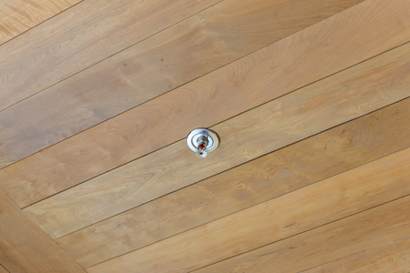 Sprinkler and smoke detector on wooden ceilingの写真素材
