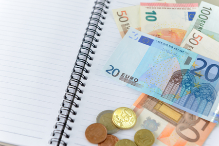 Money euro banknotes and coins on notebookの写真素材