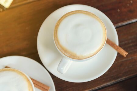 Top view of hot coffee cappuccino cup with milk foam on wood tableの写真素材