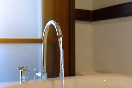 water from faucet to bathtub in bathroomの写真素材