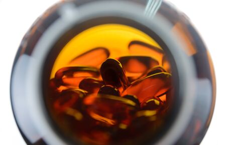 Fish oil capsules in glass bottle on white background. soft gels capsulesの写真素材