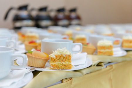 Carrot cake with fruit tart and empty cups waiting for banquet coffee timeの写真素材