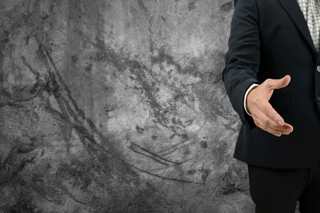 Asia Businessman open hand for handshake to make a deal and blank wall for text and background. Copy Spaceの写真素材