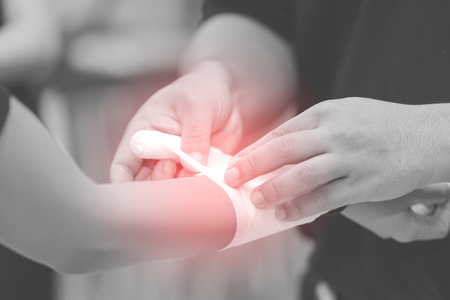Close up of bandaging injured hand after an accidentの写真素材